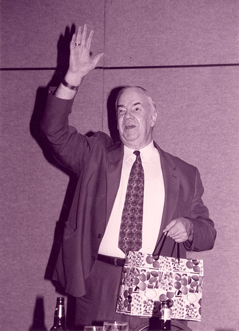 Oral Miller gets up from his chair, bright gift bag in hand, to give his remarks to the “Miller Time” convention in 1998. He thanked everyone for the gifts and gave a “farewell” wave. 