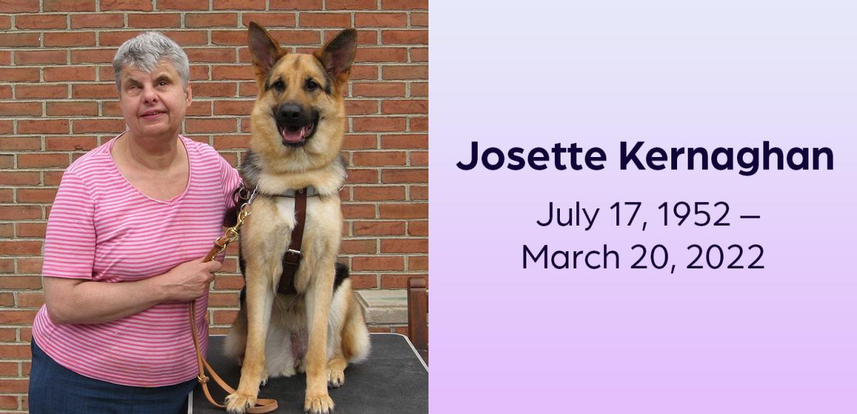 Josette smiles as she stands next to a german shepherd guide dog that is sitting on a table. Josette Kernaghan, July 17, 1952 – March 20, 2022 .
