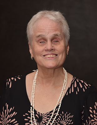 Denise Colley, dressed up and smiling in 2022