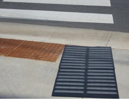 Mid-block sidewalk crossing with raised bars