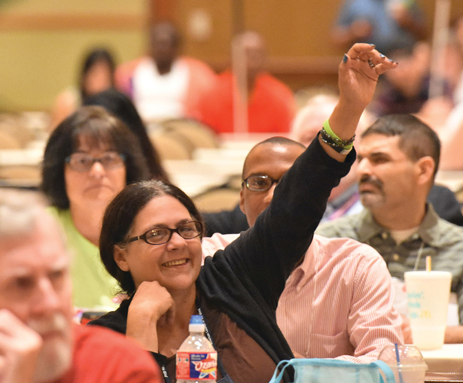 Woman with hand up to ask a question in group session